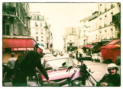 Rue des Abbesses dos à l'entrée du Café Bruant. Deux gars de la Bande avec leur moto...